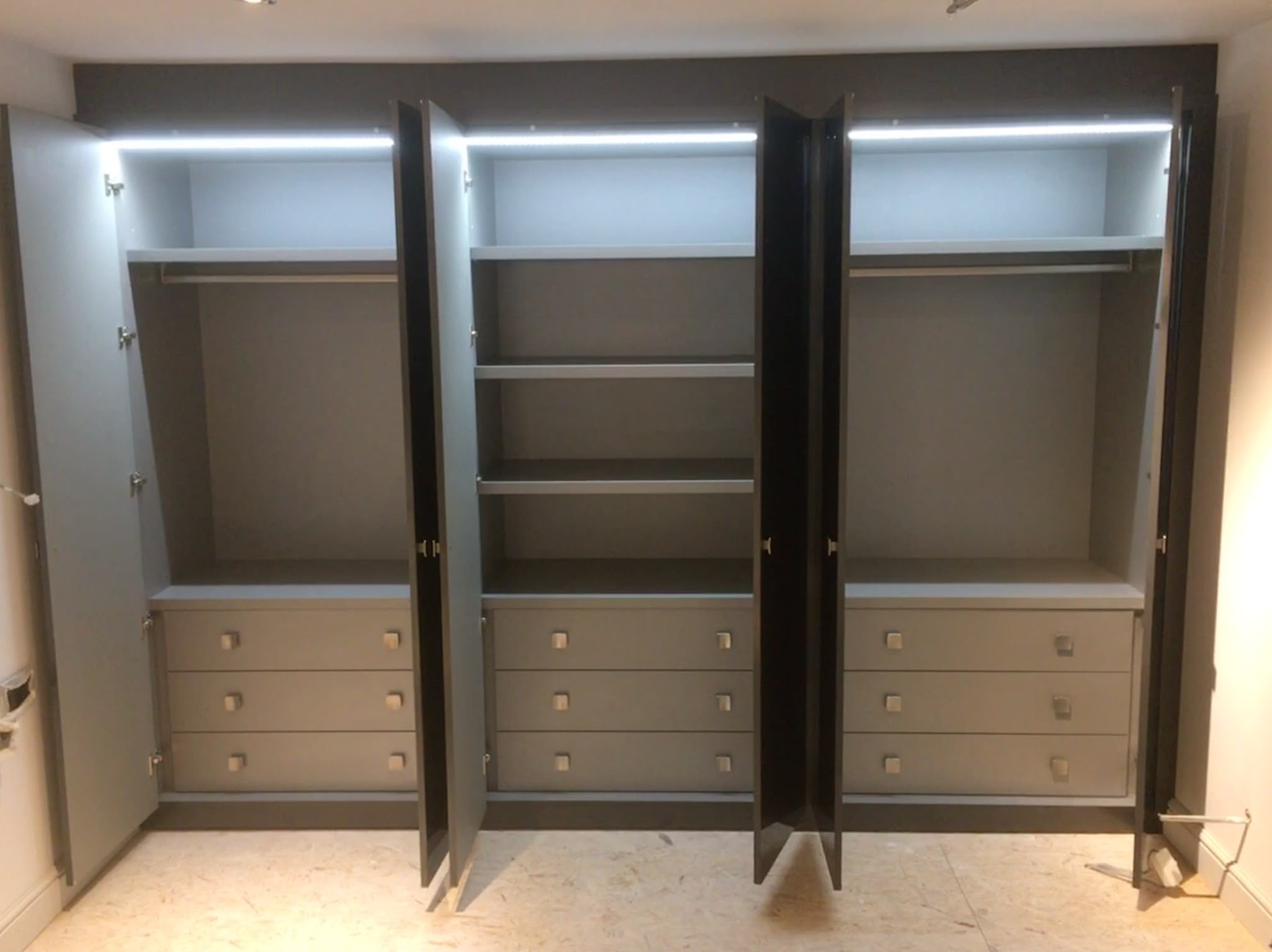 Bespoke attic dressing room with fitted sage green wardrobes and LED lighting